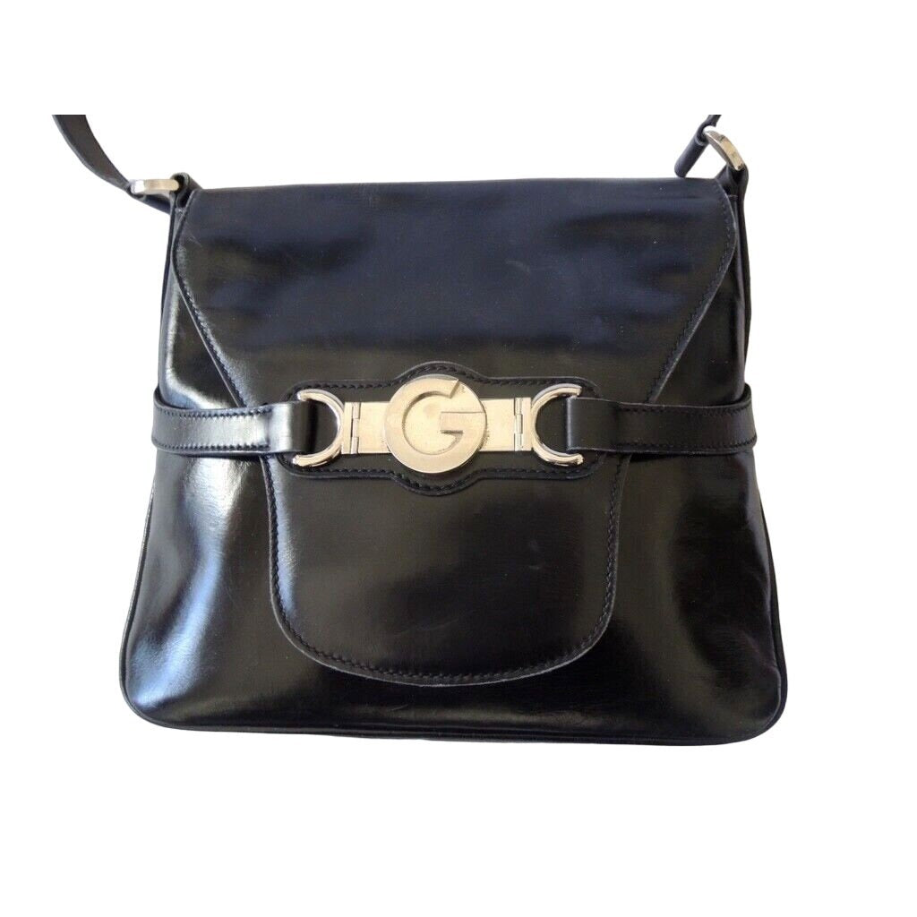 1970s Gucci saddle bag in black leather with muted gold hardware, an expandable bottom, wide shoulder strap, and burgundy leather lining