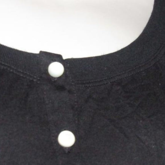 Moschino, size 10, black, 100% rayon knit top with a scoop neck, four button front placket, pearly buttons, and red, brown, white, black abstract floral print cap sleeves