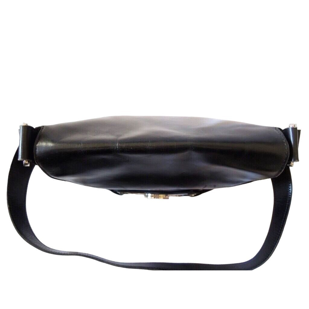 1970s Gucci saddle bag in black leather with muted gold hardware, an expandable bottom, wide shoulder strap, and burgundy leather lining