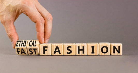 Concept words Fast fashion and Ethical fashion on wooden cubes. Businessman hand. Beautiful grey background.