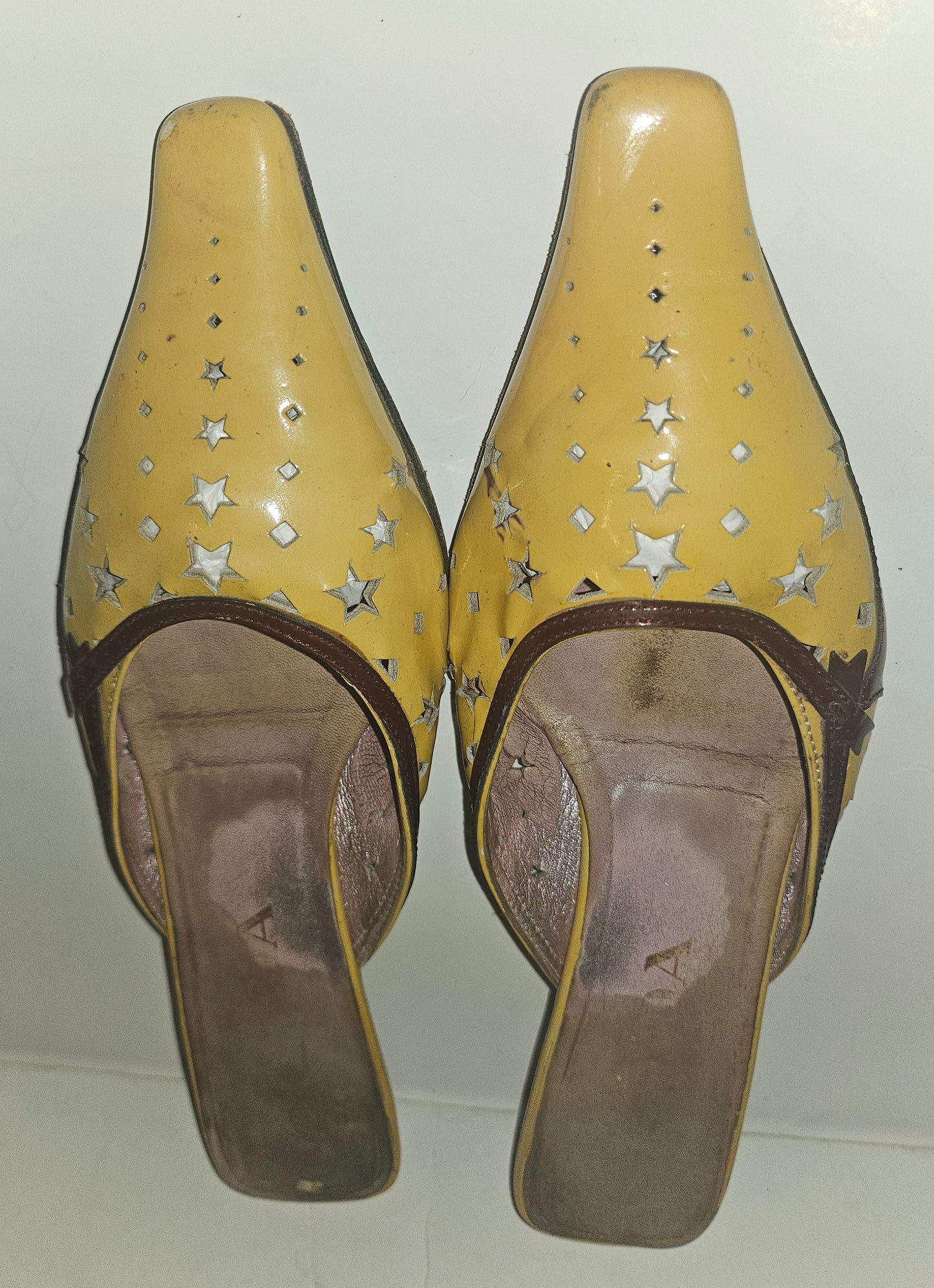 Prada kitten heel mules in yellow, brown, & dark red with star cut outs