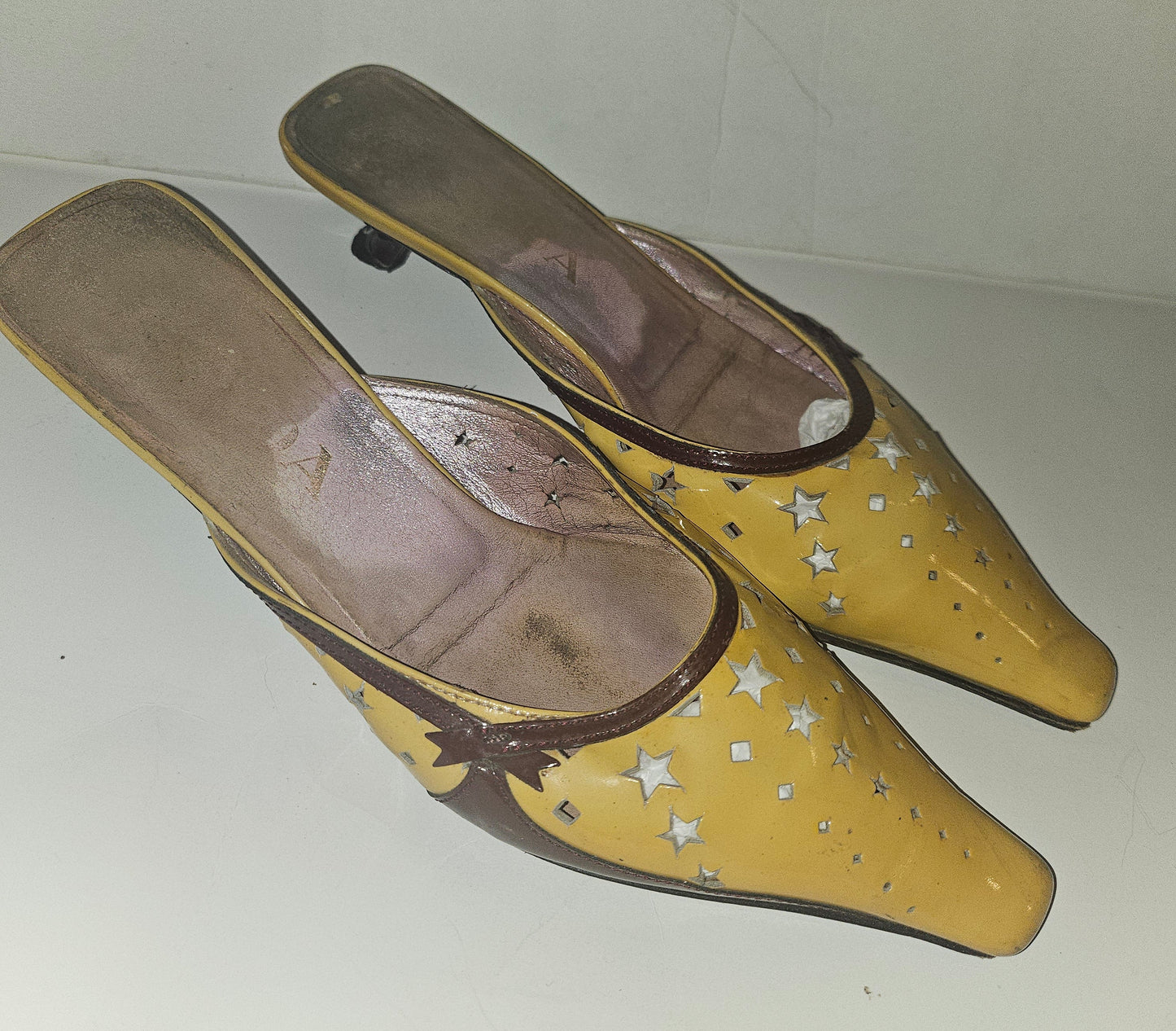 Prada kitten heel mules in yellow, brown, & dark red with star cut outs