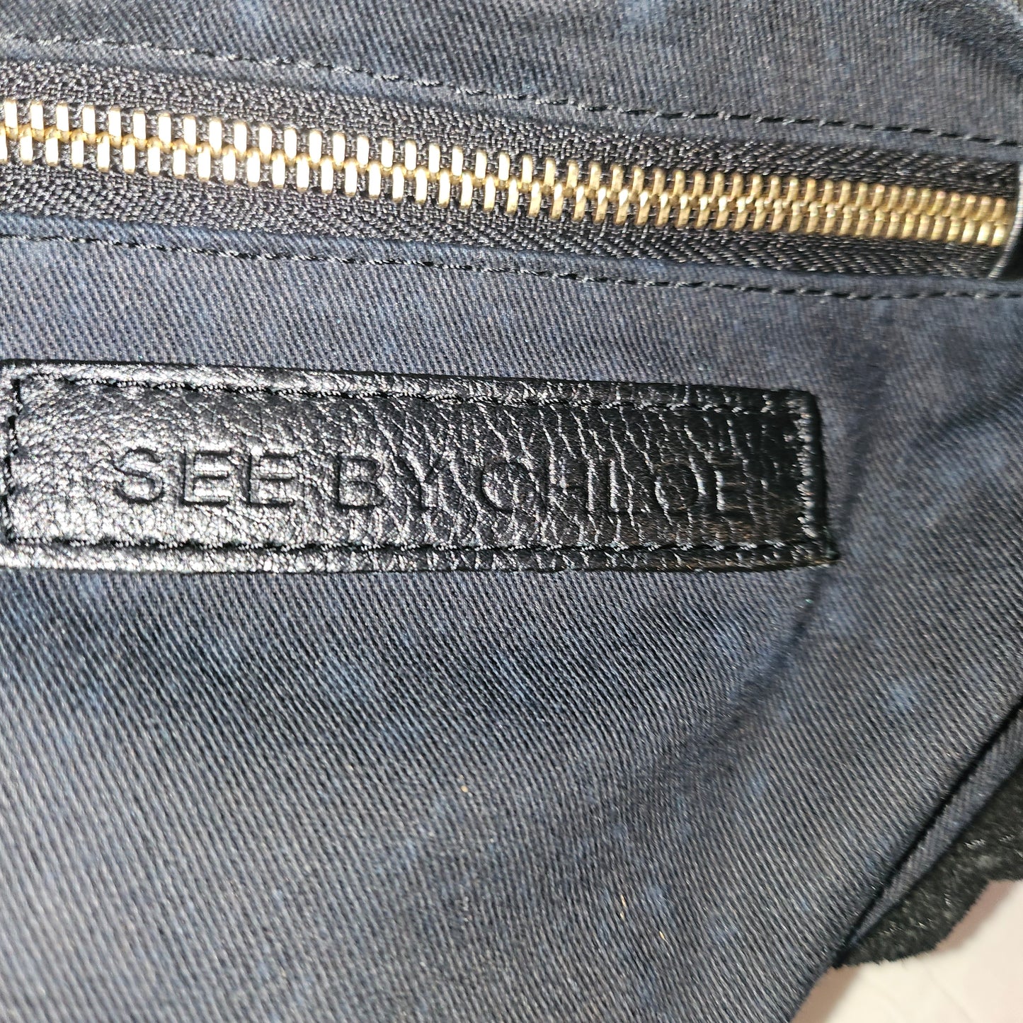 See By Chloe black pebbled leather saddle bag with two leather flowers