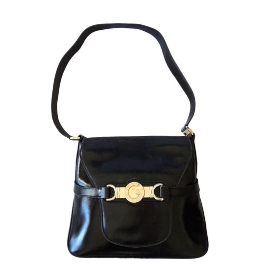 1970s Gucci saddle bag in black leather with muted gold hardware, an expandable bottom, wide shoulder strap, and burgundy leather lining