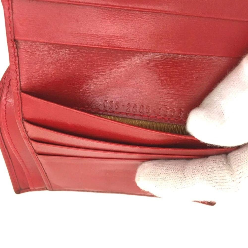 Gucci, red leather, bi-fold style, wallet with multiple pockets, tons of card slots, & a gold, engraved 'GUCCI' horseshoe accent