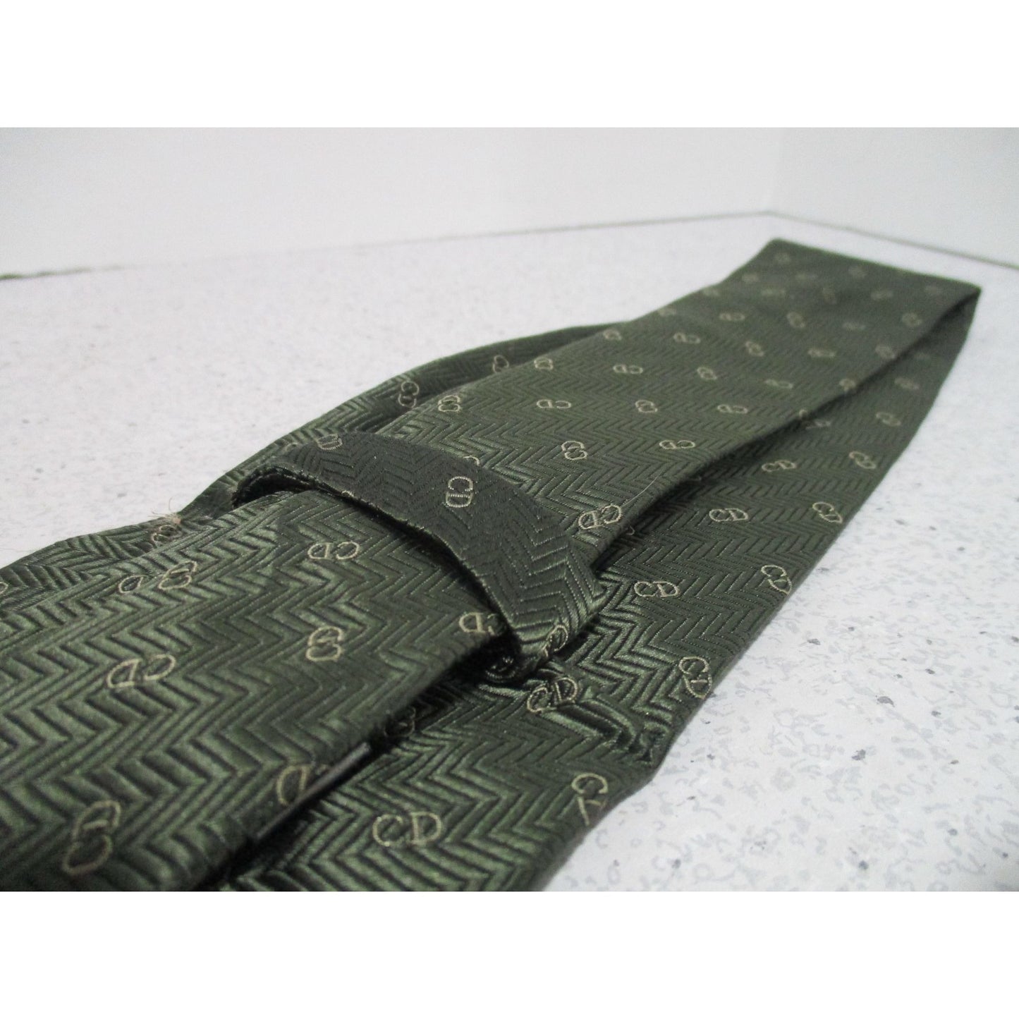 Vintage Christian Dior tie made of 100% textured, olive green silk with a logo print in shades of tan