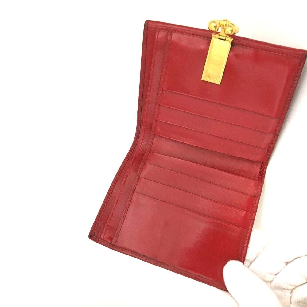 Gucci, red leather, bi-fold style, wallet with multiple pockets, tons of card slots, & a gold, engraved 'GUCCI' horseshoe accent