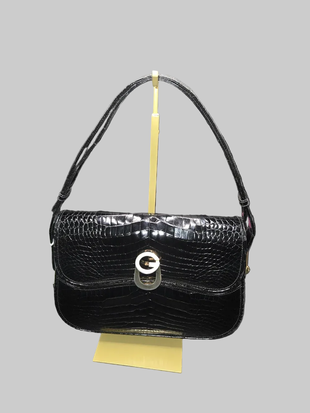 Gucci black crocodile leather shoulder purse with a bold gold 'G' accent