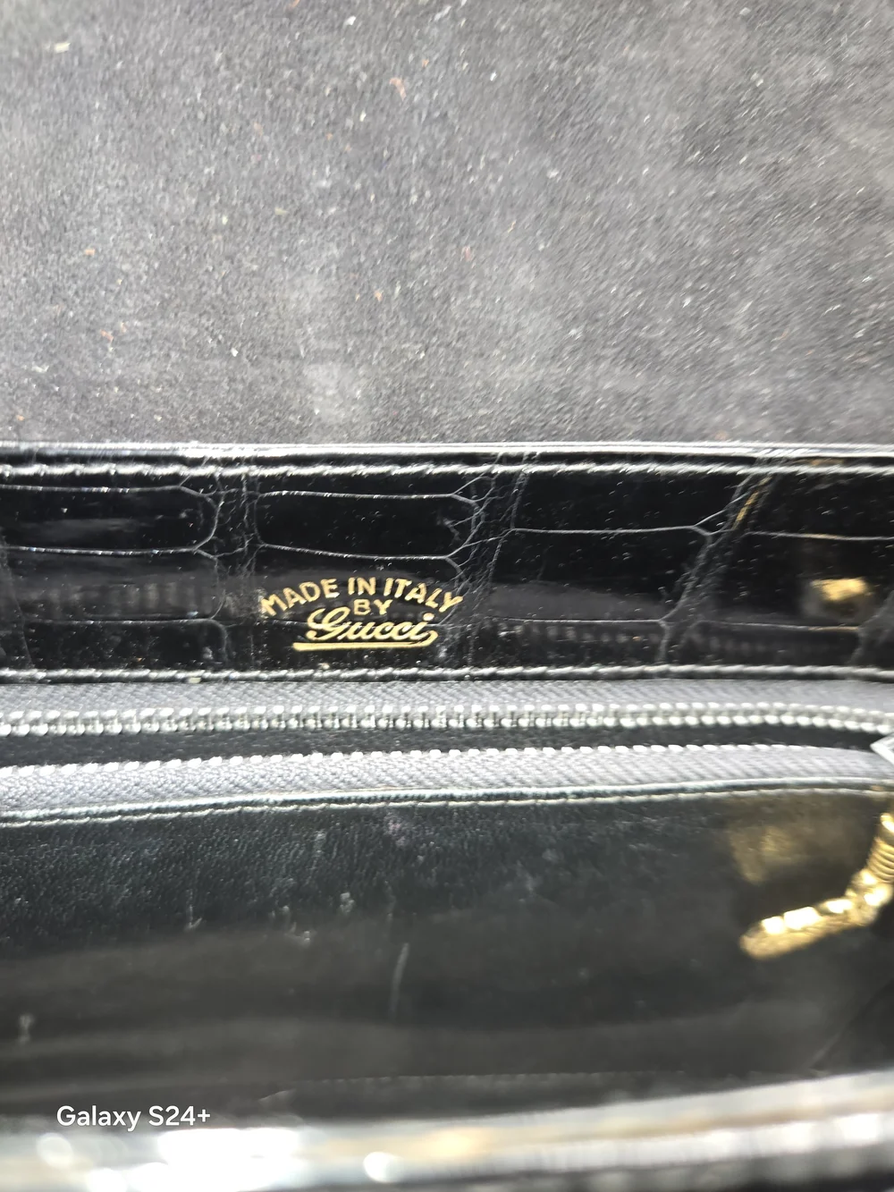 Gucci black crocodile leather shoulder purse with a bold gold 'G' accent
