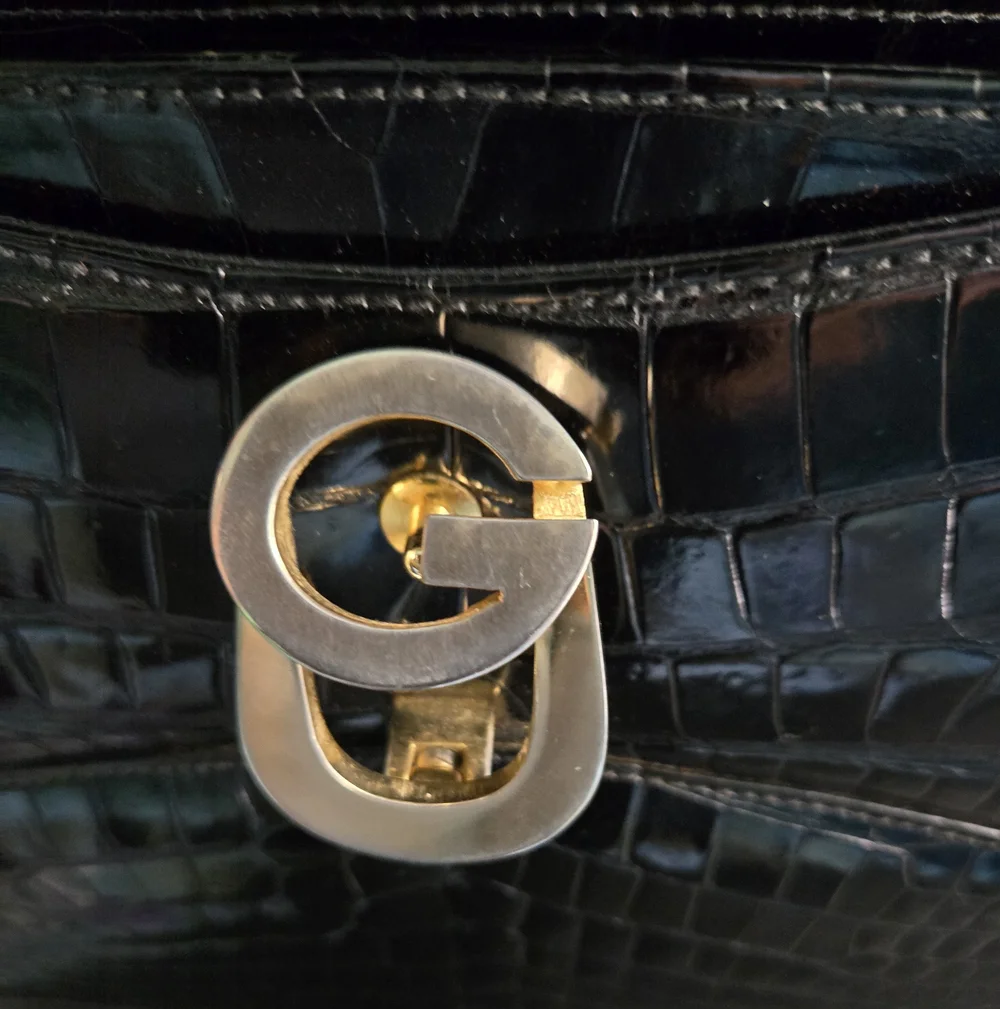 Gucci black crocodile leather shoulder purse with a bold gold 'G' accent