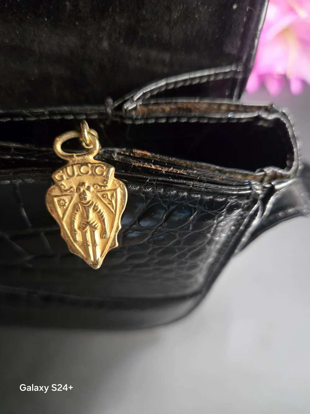 Gucci black crocodile leather shoulder purse with a bold gold 'G' accent