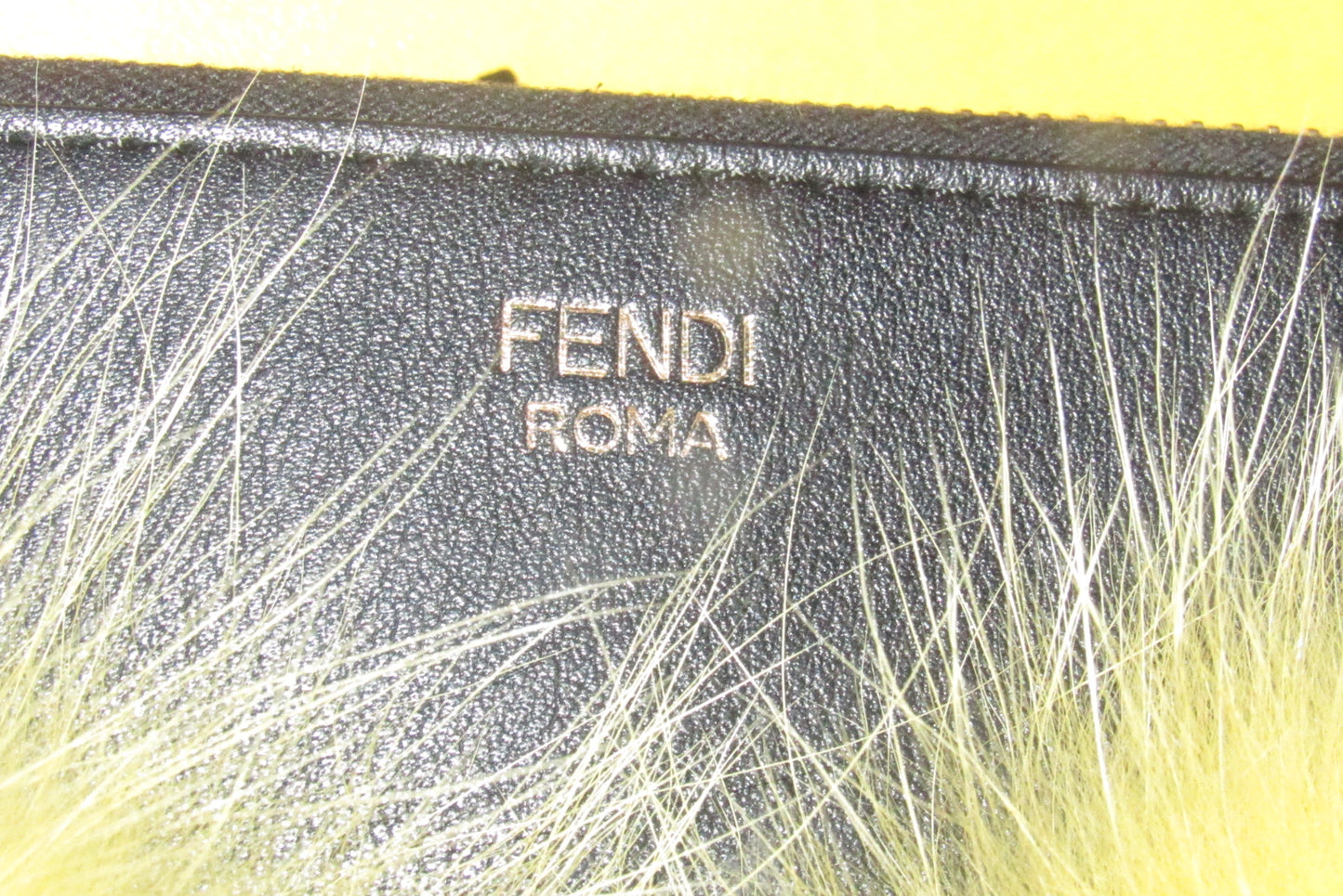 Fendi NIB w tags, black leather 'Monster' clutch w yellow fur lashes and zip around closure